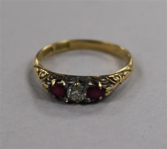 An early-mid 20th century 18ct gold ruby and diamond three stone ring, size P.